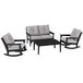 A black and grey POLYWOOD outdoor furniture set with a table and rocking chairs.