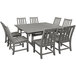 A POLYWOOD gray farmhouse trestle dining table with chairs on an outdoor patio.