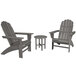 A round table with a slate grey top on a outdoor patio with two slate grey wooden POLYWOOD chairs with armrests.