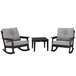 Two black POLYWOOD rocking chairs with a side table.