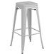 A silver metal Lancaster Table & Seating backless barstool with a gray wood seat.