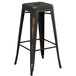 A black metal Lancaster Table & Seating barstool with a gray wood seat.