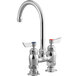 a silver faucet with red knobs