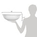 A silhouette of a person holding a clear polycarbonate bowl.