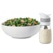A bowl of salad with OXO Good Grips Twist & Pour Salad Dressing Mixer on the side.