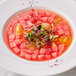 A bowl of Les Vergers Boiron watermelon puree with watermelon cubes and vegetables.