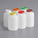 A group of white Choice plastic containers with assorted color lids.