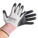 A pair of hands wearing black and white Cordova Machinist cut resistant gloves.