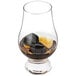 A glass of whiskey with Outset black granite whiskey stones.
