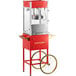 A red and silver Carnival King popcorn machine on a cart with a wheel.
