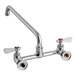 A Regency chrome wall mount faucet with 12" swing spout and two knobs.