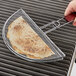 A hand using the Outset Quesadilla Grill Basket on a grill.