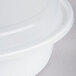 A close-up of a white Pactiv plastic container with a lid.