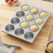 A Baker's Mark muffin tin with jumbo muffins on a wooden surface.