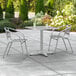 A Lancaster Table & Seating outdoor table with two chairs on a patio.
