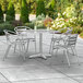 A Lancaster Table & Seating outdoor table with four chairs on a patio.