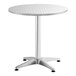 A Lancaster Table & Seating round stainless steel outdoor table with a metal base.