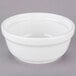 A Tuxton white china casserole bowl with a lid on a gray surface.