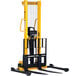A Vestil manual hydraulic forklift with black and yellow handles.