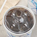 A Choice translucent cold cup lid with a straw slot on a cup of ice with a straw.