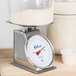An Edlund heavy-duty portion scale on a counter weighing a container of rice.