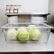 A Carlisle clear food storage box on a counter filled with cabbages.
