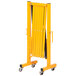 A yellow metal Vestil Expand-A-Gate safety gate with casters.