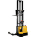 A yellow and black Vestil powered dual mast fork stacker with straddle legs.