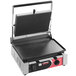 A Sirman single panini grill with a black and red surface and a lid.