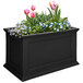 A black rectangular Mayne Fairfield planter with pink flowers.
