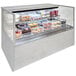 A Structural Concepts refrigerated self-service display case with cakes and pastries on shelves.