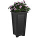 A Mayne black planter with a plant in it.