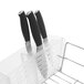 An OXO Good Grips stainless steel folding dish rack on a counter with knives in it.