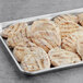 A tray of Brakebush Easy Gourmet grilled chicken fillets on a gray surface.