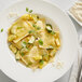 A white bowl of pasta and vegetables seasoned with Sabatino Tartufi Truffle Zest & Cheese seasoning.