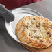 An 8" aluminum wide rim pizza pan with a cheese pizza on a table.
