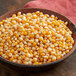 A bowl of Pop Weaver caramel and sweet mushroom popcorn kernels on a table.