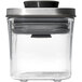 A clear plastic OXO Good Grips food storage container with a stainless steel lid.