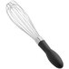 An OXO Good Grips whisk with a black handle.