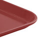 A close-up of a red Cambro Camlite tray with a handle.