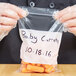 A person holding a LK Packaging plastic food bag of carrots with a white write on block.