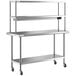 A silver stainless steel Regency expeditor table with double shelves on wheels.