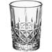 A close up of a clear Acopa shot glass with a diamond pattern.