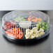 A Fineline clear plastic high dome lid on a tray of vegetables.