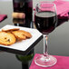 A close-up of a Chef & Sommelier cordial wine glass filled with wine on a table with cookies.