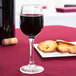 A Chef & Sommelier Cabernet cordial wine glass filled with wine on a table with crackers.