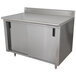 A stainless steel cabinet with doors and a shelf on a stainless steel work table.