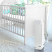 A white rectangular Guardian Technologies air purifier on a white crib.