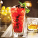 A Libbey Inverness beverage glass filled with ice and red liquid with a leafy garnish.