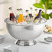 A Choice stainless steel punch bowl filled with soda bottles and ice on a table.